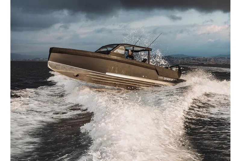 Slide: The Image of 2027 XO DFNDR A8 boat navigating rough waters with dynamic waves and cloudy sky. - 10
