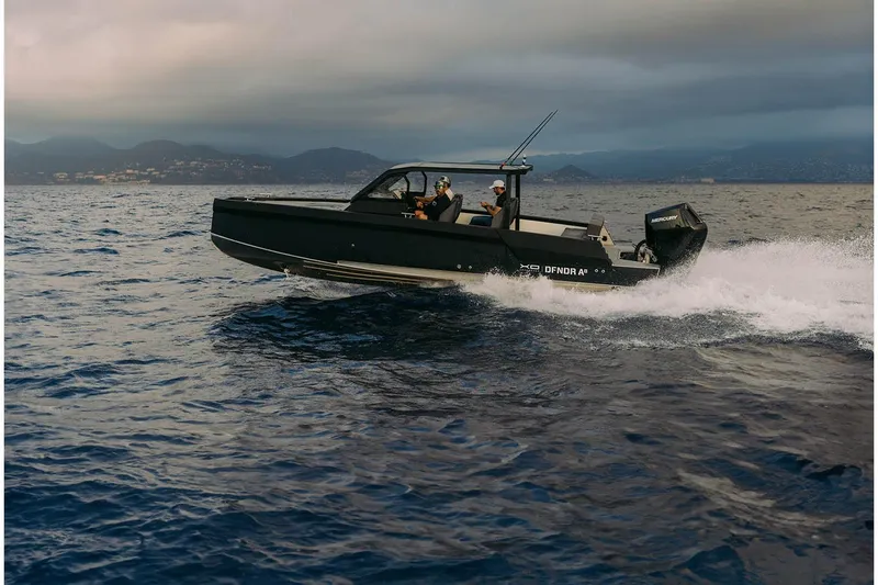 Slide: The Image of 2027 XO DFNDR A8 boat cruising on open water under cloudy skies. - 11