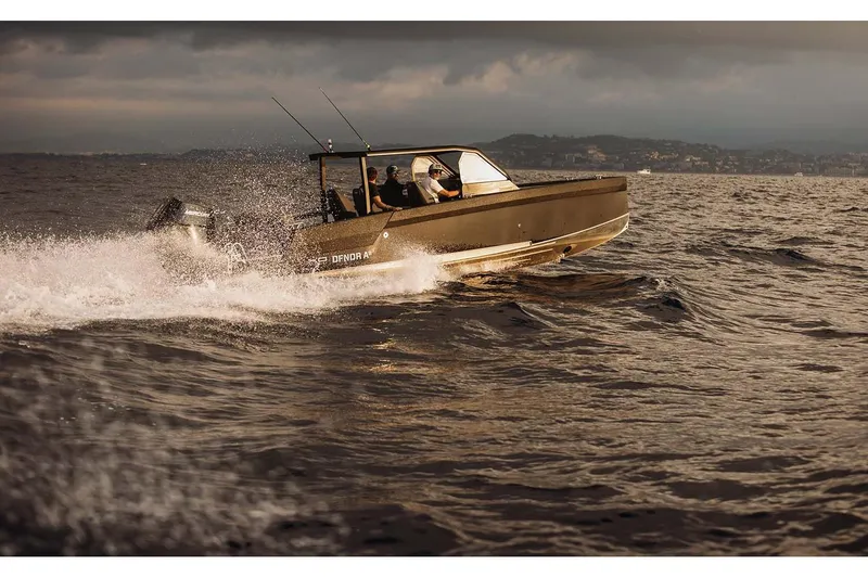 Slide: The Image of 2027 XO DFNDR A8 boat cruising on open water under cloudy skies. - 13