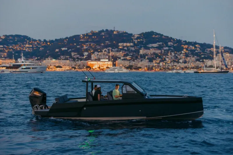 Slide: The Image of XO DFNDR A8 boat cruising at dusk near a cityscape, 2027 model. - 3