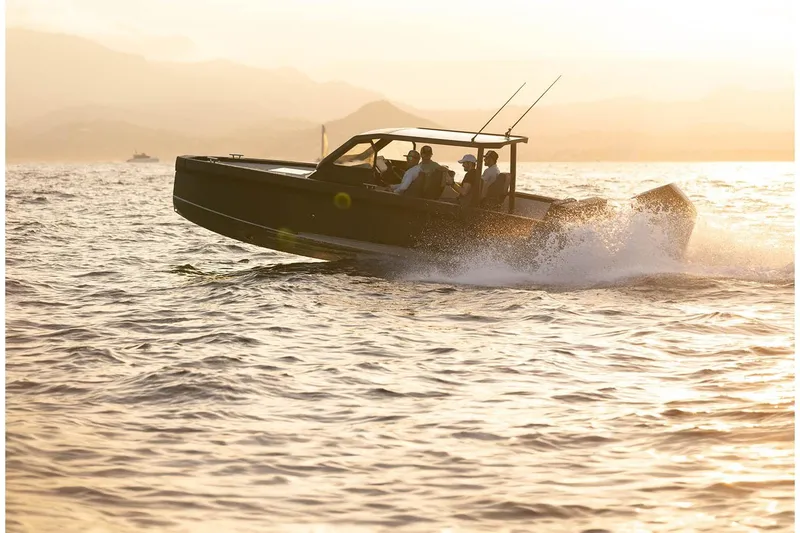 Slide: The Image of 2027 XO DFNDR A8 boat cruising at sunset on open water. - 7