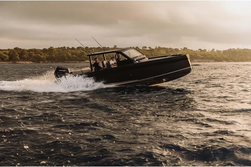 Slide: The Image of 2027 XO DFNDR A8 boat cruising on open water at sunset. - 9