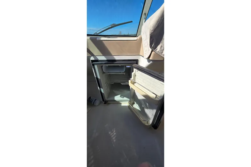 Slide: The Image of Open refrigerator inside 2006 Carver 36 Mariner boat, with sunlight streaming through window. - 16