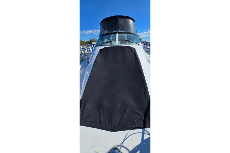 Slide: The Image of 2006 Carver 36 Mariner boat with black cover, docked under clear blue sky. - 20