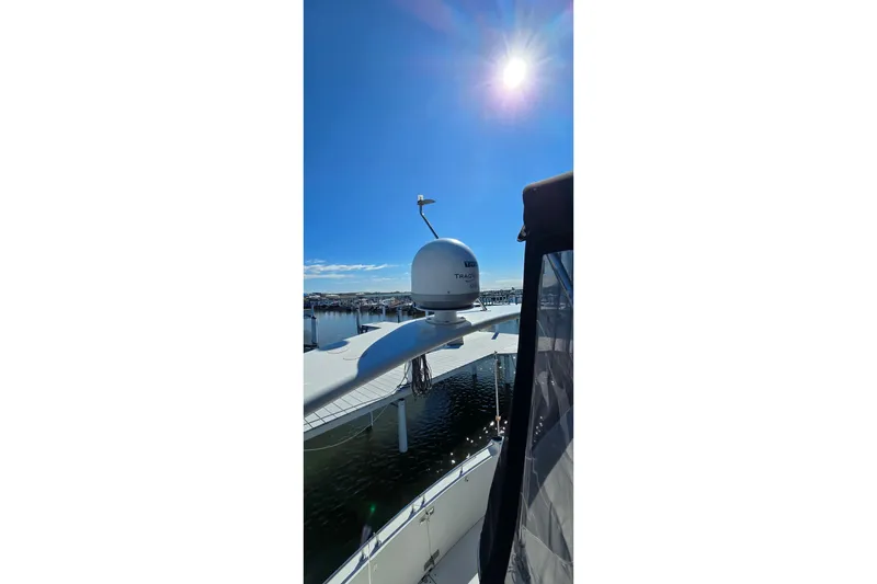 Slide: The Image of 2006 Carver 36 Mariner yacht with radar, docked under a bright sunlit sky. - 22