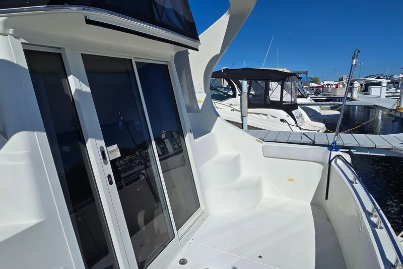 Slide: The Image of 2006 Carver 36 Mariner yacht docked, featuring sleek design and spacious deck area. - 25