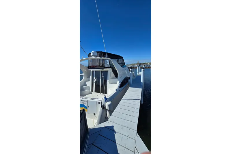 Slide: The Image of 2006 Carver 36 Mariner yacht docked at marina under clear blue sky. - 4