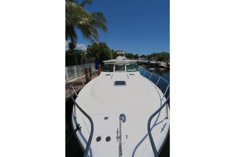 Slide: The Image of 2005 Tiara Yachts 3800 Open docked, showcasing sleek design and spacious deck. - 11
