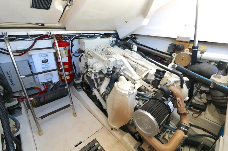 Slide: The Image of Engine room of a 2005 Tiara Yachts 3800 Open, featuring mechanical components and fire extinguisher. - 13