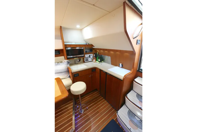 Slide: The Image of 2005 Tiara Yachts 3800 Open interior kitchen with wood cabinetry and modern appliances. - 2