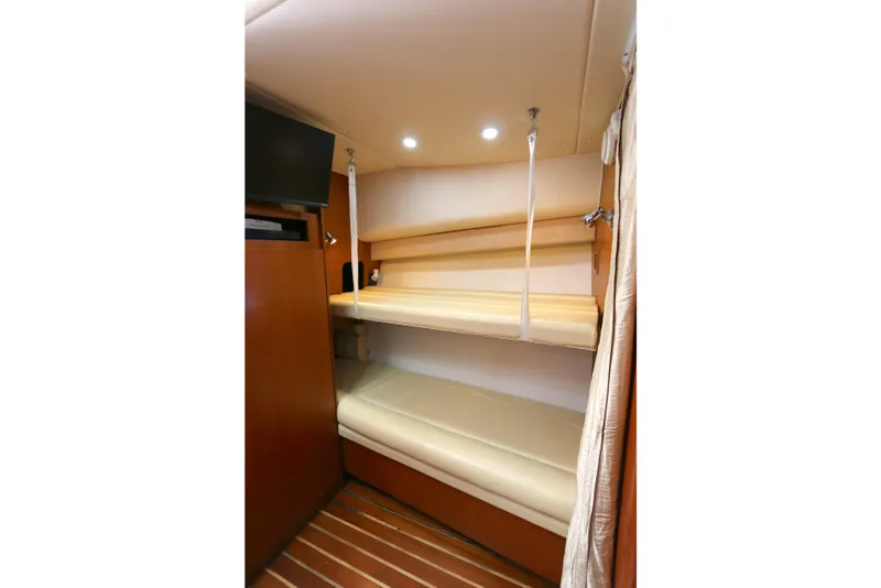 Slide: The Image of Interior of 2005 Tiara Yachts 3800 Open with bunk beds and wooden cabinetry. - 7