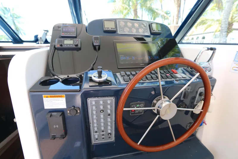 Slide: The Image of Helm of 2005 Tiara Yachts 3800 Open with steering wheel and navigation controls. - 8