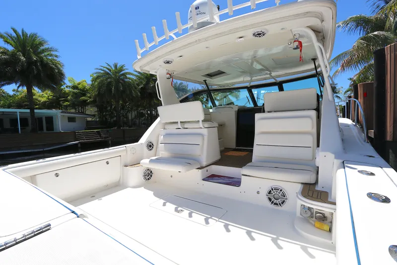 Slide: The Image of 2005 Tiara Yachts 3800 Open with spacious seating and sleek design, docked under palm trees. - 9
