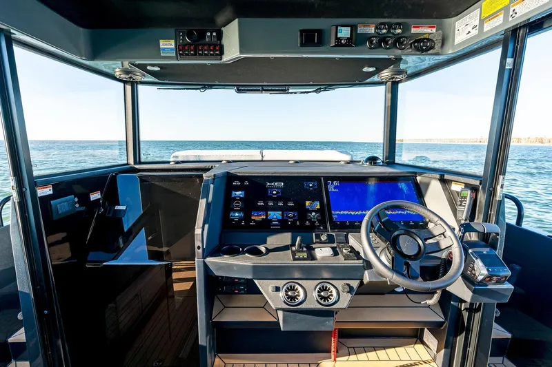 Slide: The Image of Helm of 2026 XO EXPLR 44 boat with advanced navigation systems and ocean view. - 16
