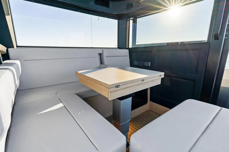 Slide: The Image of Interior of 2026 XO EXPLR 44 yacht with modern seating and wooden table. - 18