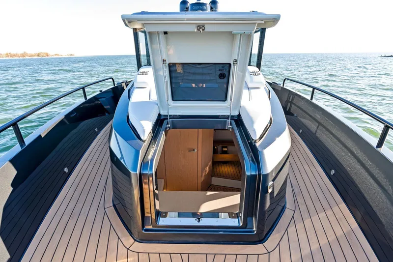Slide: The Image of 2026 XO EXPLR 44 boat with open cabin door, sleek deck design, and ocean view. - 7