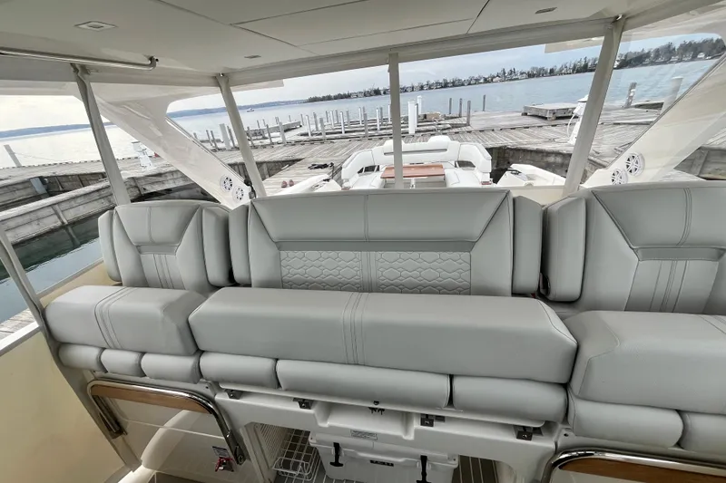 Slide: The Image of Luxurious seating on 2023 Tiara Yachts 43 LS, docked by serene waters. - 16