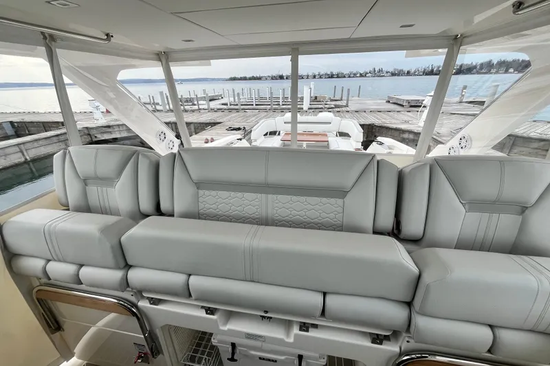 Slide: The Image of Luxurious seating on 2023 Tiara Yachts 43 LS, overlooking serene marina view. - 17