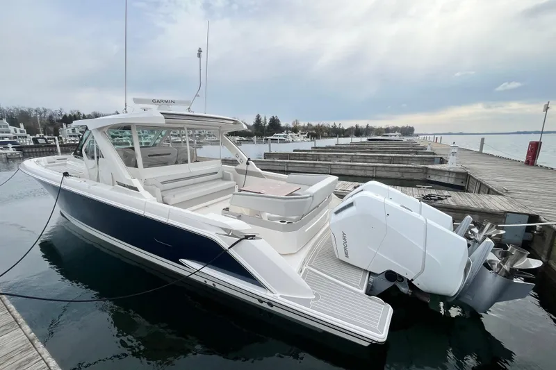 Slide: The Image of 2023 Tiara Yachts 43 LS docked, showcasing sleek design and powerful outboard engines. - 2