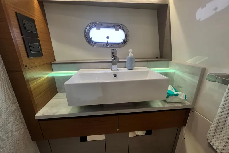 Slide: The Image of Modern bathroom sink in 2023 Tiara Yachts 43 LS, featuring sleek design and porthole window. - 27