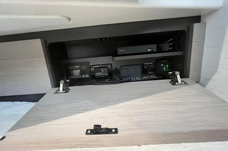 Slide: The Image of Control panel inside 2023 Tiara Yachts 43 LS, featuring electronic equipment and storage. - 28
