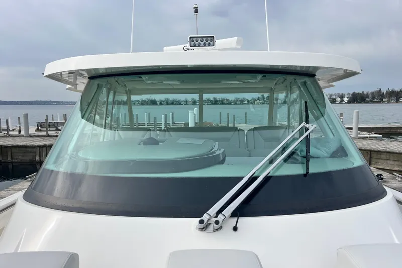 Slide: The Image of 2023 Tiara Yachts 43 LS boat docked, showcasing sleek windshield design. - 32