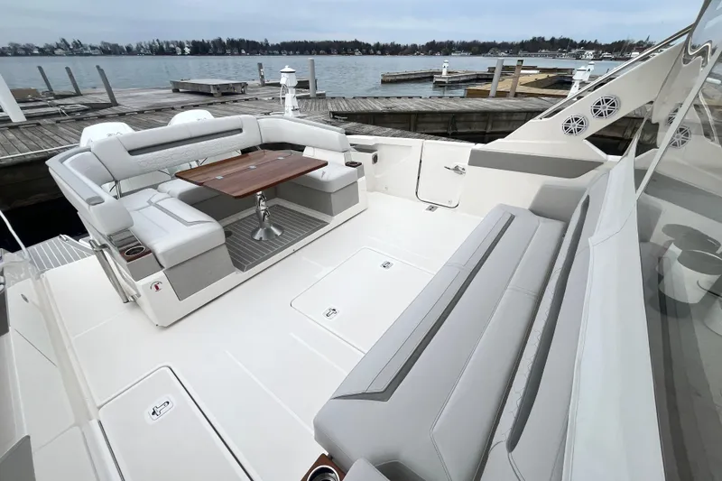 Slide: The Image of 2023 Tiara Yachts 43 LS luxury yacht deck with seating and table by the water. - 6