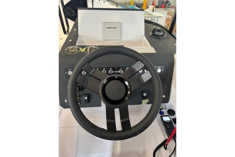 Slide: The Image of Steering wheel of 2026 XO EXPLR 9 boat with control panel and compass. - 26