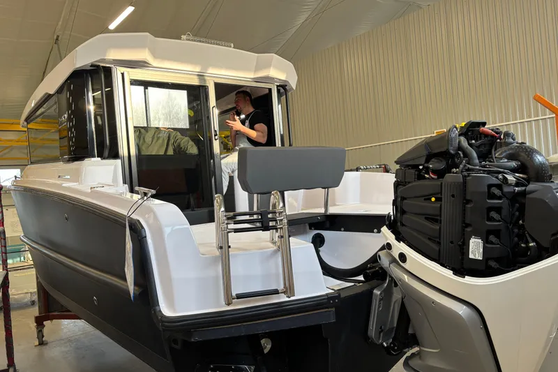 Slide: The Image of 2026 XO EXPLR 9 boat in a workshop, featuring a visible engine and interior view. - 6