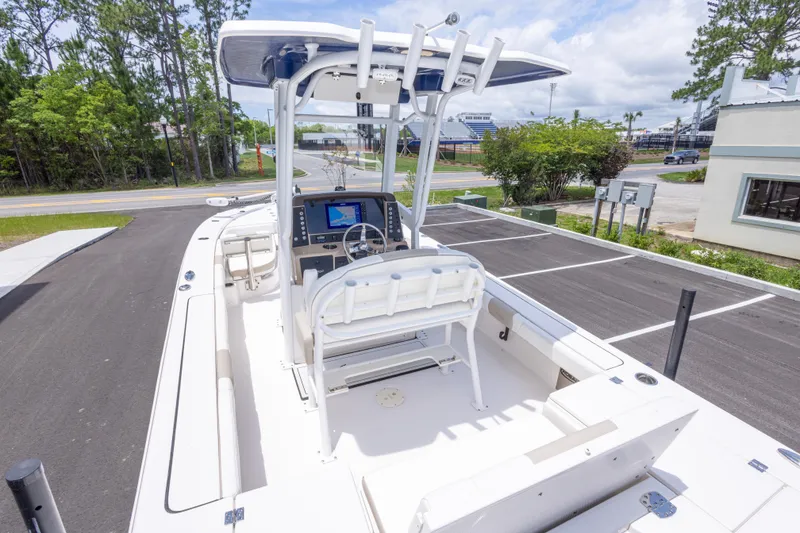 Slide: The Image of 2024 Robalo 246 Cayman boat with helm station and seating, parked outdoors. - 12