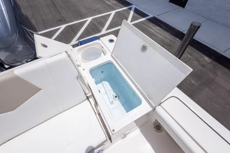 Slide: The Image of 2024 Robalo 246 Cayman boat with open storage compartment and seating area. - 16