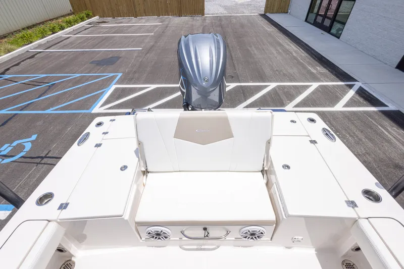 Slide: The Image of 2024 Robalo 246 Cayman boat interior with seating and engine in a parking lot. - 18