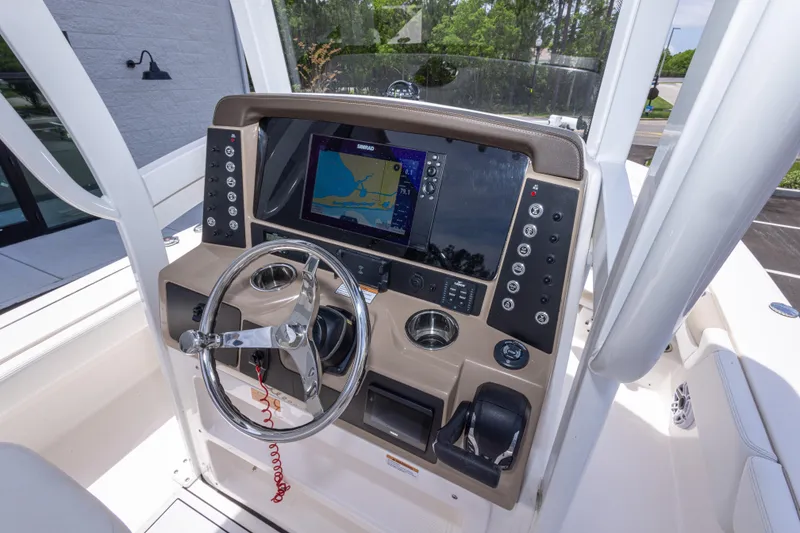 Slide: The Image of 2024 Robalo 246 Cayman boat dashboard with navigation display and steering wheel. - 23