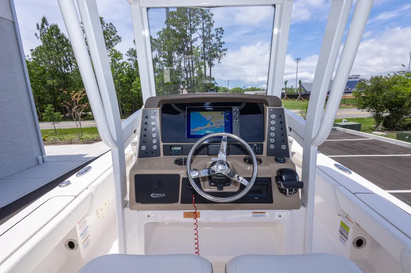 Slide: The Image of 2024 Robalo 246 Cayman boat helm with navigation display and steering wheel. - 24