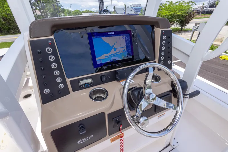 Slide: The Image of 2024 Robalo 246 Cayman boat dashboard with navigation screen and steering wheel. - 25