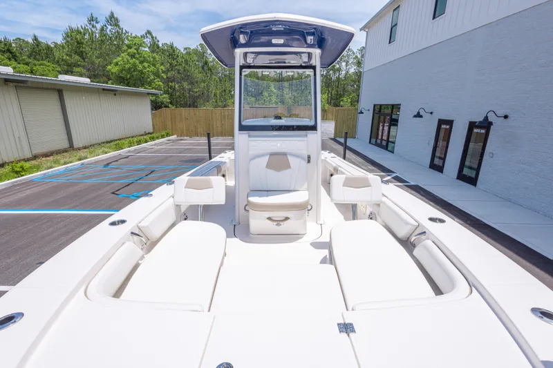 Slide: The Image of 2024 Robalo 246 Cayman boat interior with seating, parked near buildings. - 32