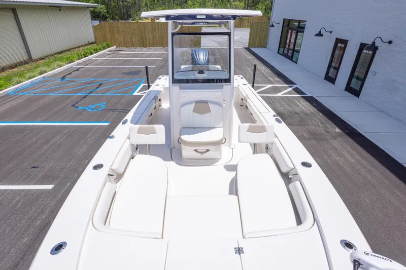Slide: The Image of 2024 Robalo 246 Cayman boat in parking lot, showcasing spacious deck and seating. - 33