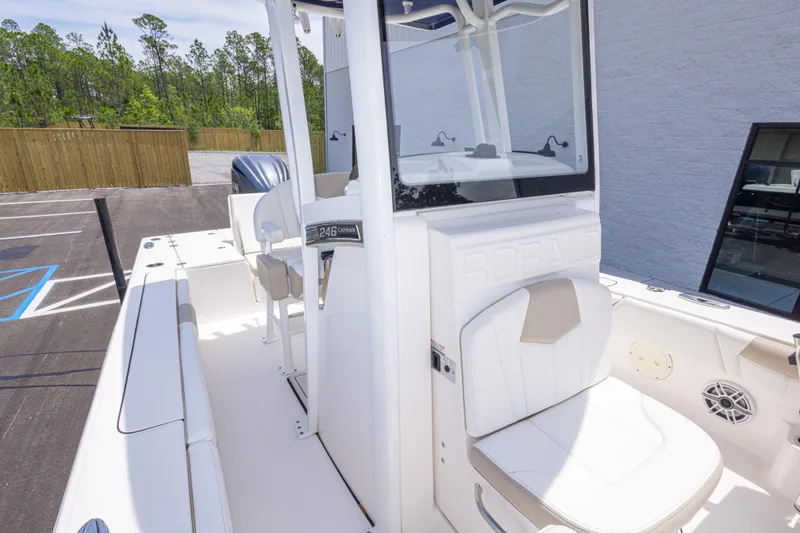 Slide: The Image of 2024 Robalo 246 Cayman boat interior with seating and console, parked outdoors. - 37