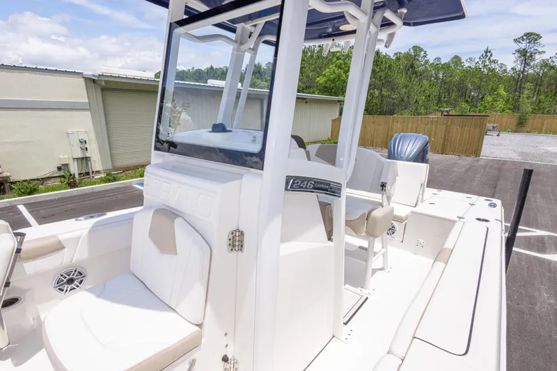 Slide: The Image of 2024 Robalo 246 Cayman boat interior with seating and console, parked outdoors. - 38