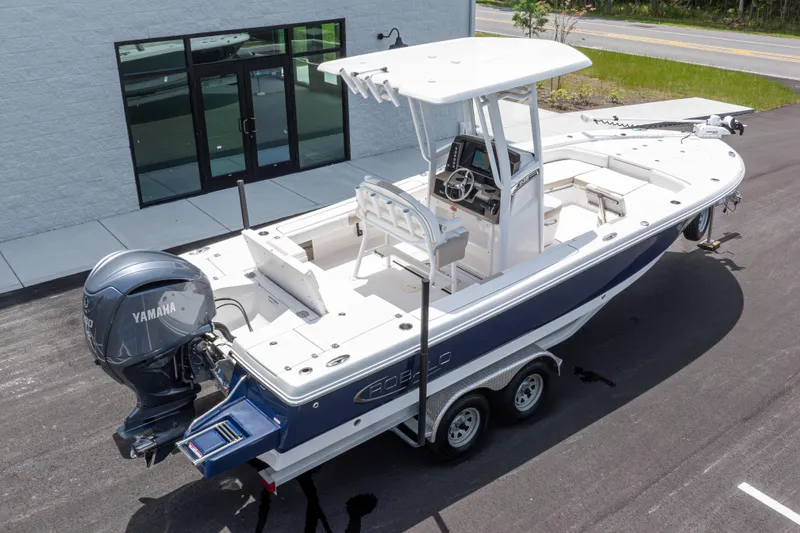 Slide: The Image of 2024 Robalo 246 Cayman boat with Yamaha engine, parked on a trailer near a building. - 45