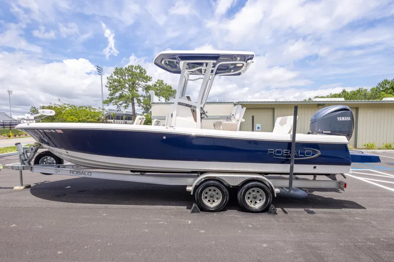Slide: The Image of 2024 Robalo 246 Cayman boat on trailer, featuring Yamaha engine, parked outdoors. - 7