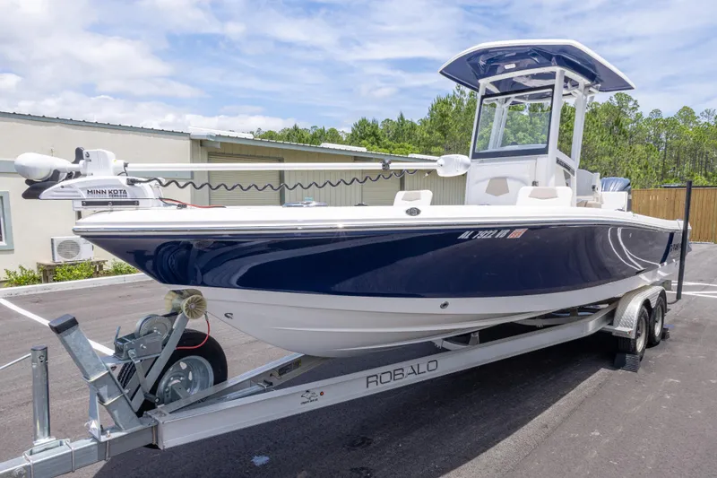 Slide: The Image of 2024 Robalo 246 Cayman boat on trailer, featuring sleek blue and white design. - 8
