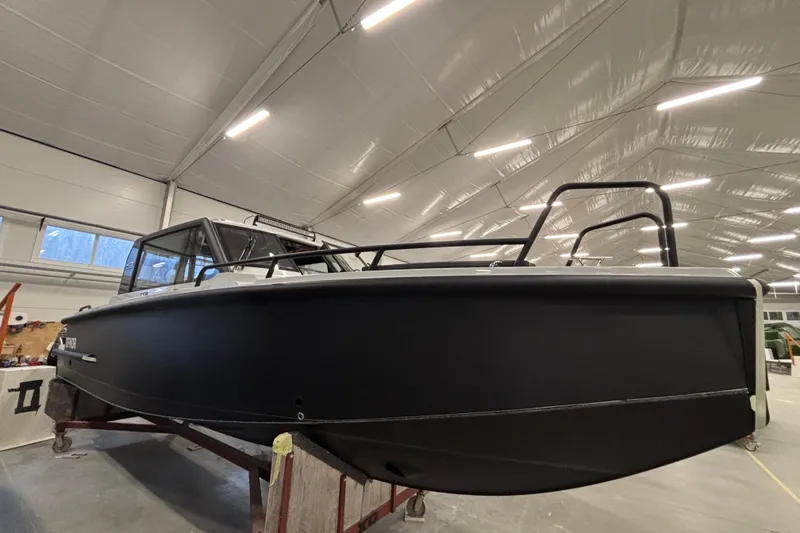 The Image of 2026 XO DFNDR 8 boat in a well-lit indoor facility, showcasing sleek design and modern features. - 1