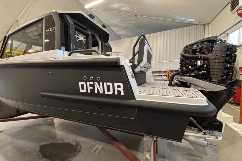 Slide: The Image of 2026 XO DFNDR 8 boat in a workshop, showcasing sleek design and powerful engine. - 2