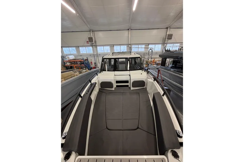 Slide: The Image of 2026 XO DFNDR 8 boat interior in a well-lit showroom, showcasing sleek seating design. - 4