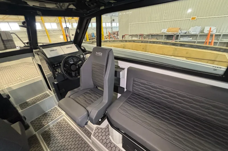 Slide: The Image of Interior of 2026 XO DFNDR 8 boat with modern seating and control panel. - 8