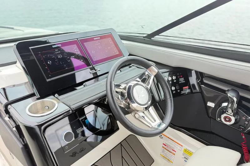 Slide: The Image of 2023 Sea Ray SLX 260 helm with dual Simrad displays and modern steering wheel. - 13