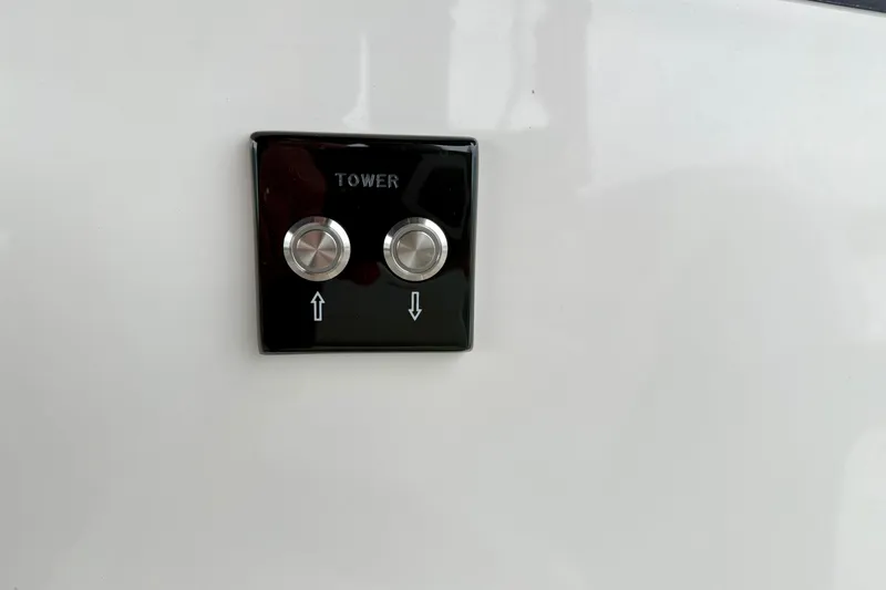 Slide: The Image of Control panel with two buttons for tower adjustment on 2023 Sea Ray SLX 260 boat. - 28