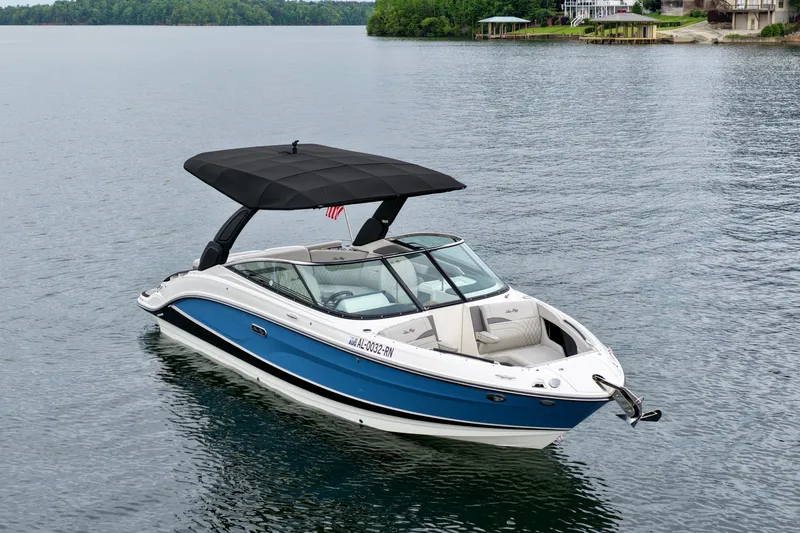 Slide: The Image of 2023 Sea Ray SLX 260 boat with black canopy on calm lake waters. - 4