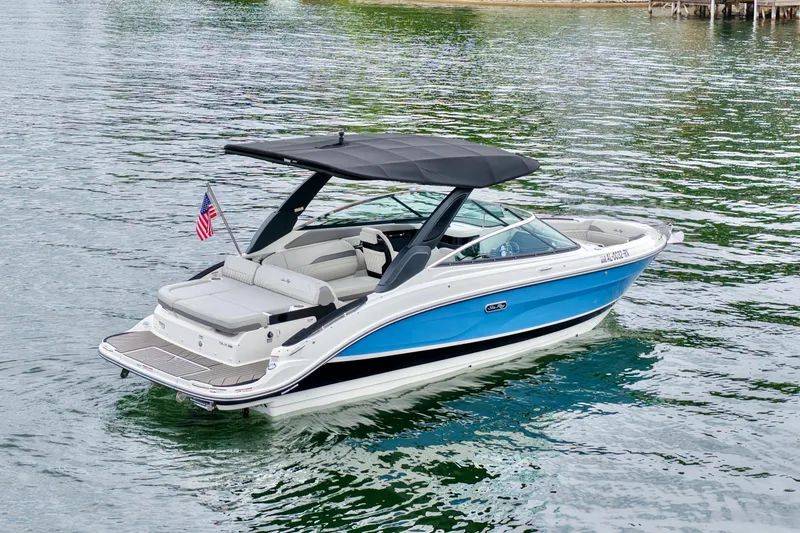 Slide: The Image of 2023 Sea Ray SLX 260 boat with blue hull, cruising on calm water. - 6